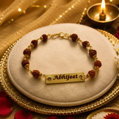 Classic rudraksha name rakhi with Abhijeet engraved on gold-plated name plate on a puja thali